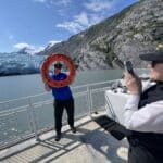 Guests pose for photos in front of the face of Portage Glacier on the 1-hour Portage Glacier Cruise.