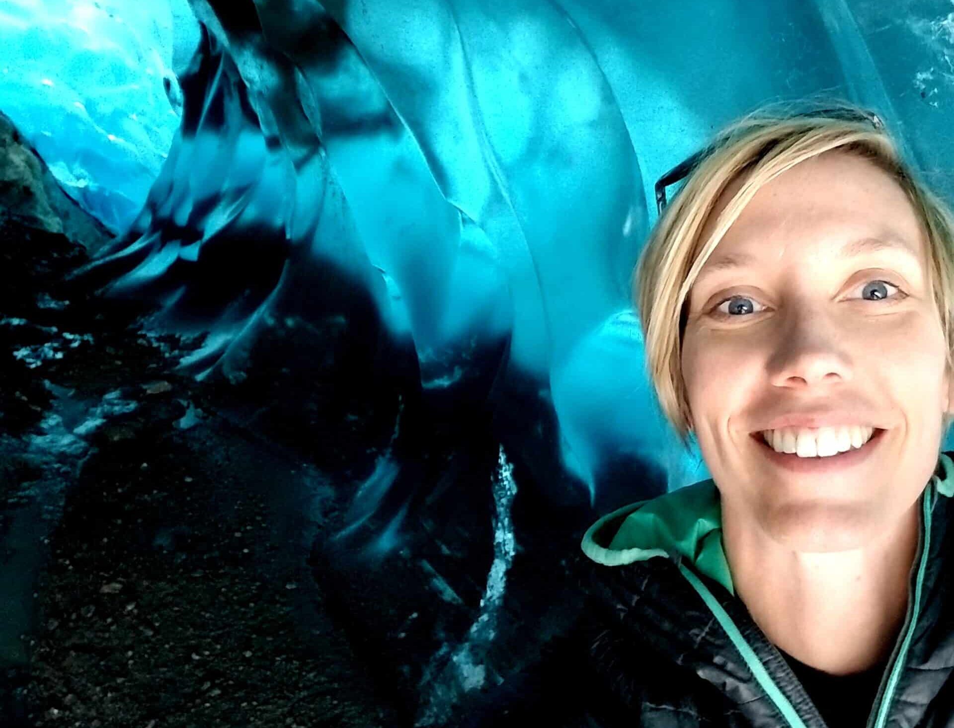 Merrideth has short blond hair and is pictured inside a perfect blue ice cave